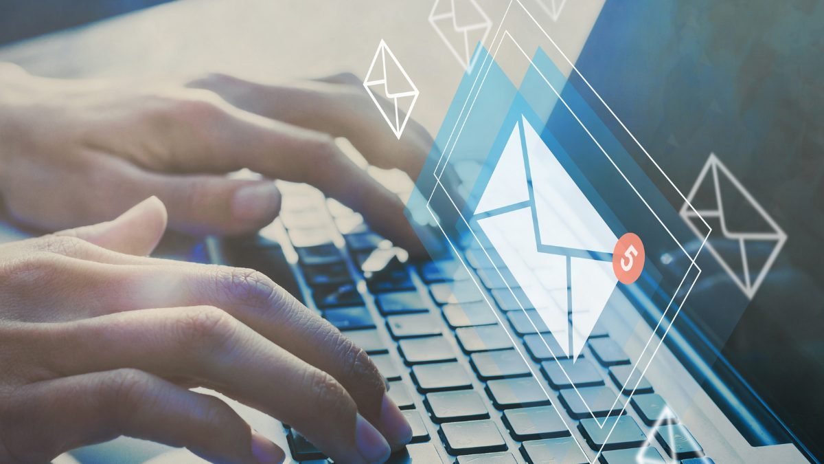 Mãos digitando em notebook com ícones de envelope de e-mail sobrepostos